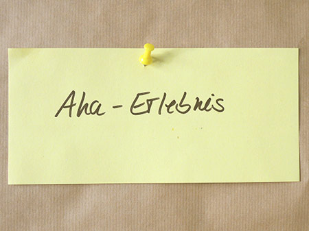 Sinnbild für berufliche Neuorientierung: Moderationskarte beschriftet mit Aha-Erlebnis