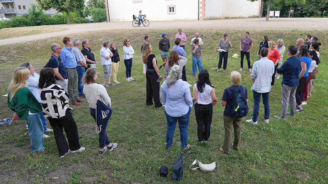 Großgruppen-Moderation draußen auf einer Wiese, Symbolbild